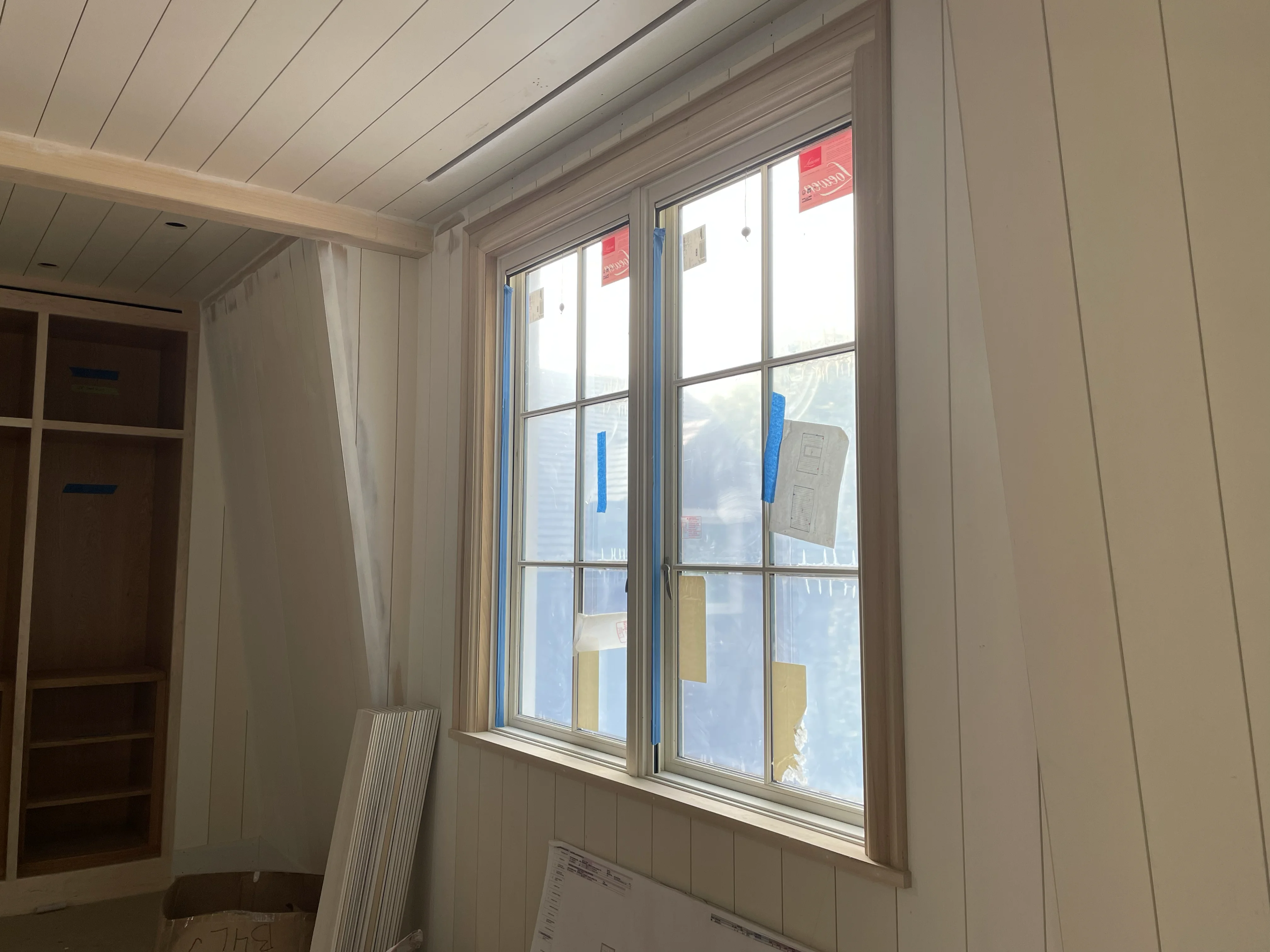 Shiplap interior walls with double windows and built-in closet framing