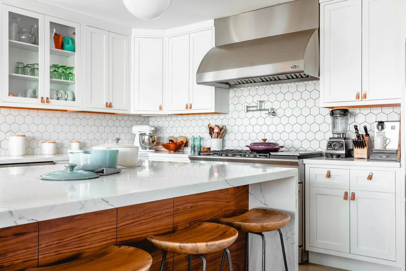 Modern kitchen remodel with white cabinets, wood island, marble countertops, and hex tile backsplash