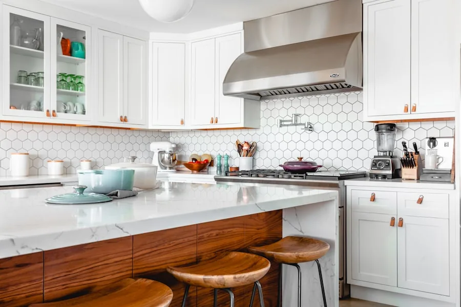 Modern kitchen remodel with white cabinets, marble island, and hex tile backsplash